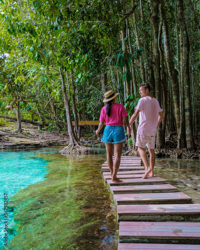 A couple visits the Emerald pool and Blue pool in Krabi Thailand, Emerald pool and Blue pool, trees, and mangroves with crystal clear water Krabi Province, Thailand.  photo