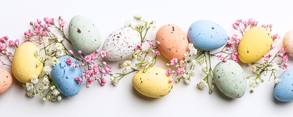 Banner of Easter quail eggs, flowers over white background. Spring holidays concept with copy space. Top view