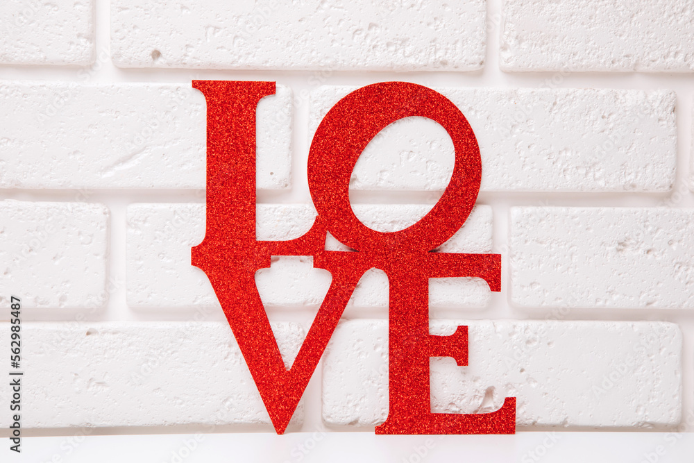 Background for Valentine's Day. The inscription love in sparkles on background of white brick wall. Front view Background for Valentine's Day. The inscription love in sparkles on background of white brick wall. Front view