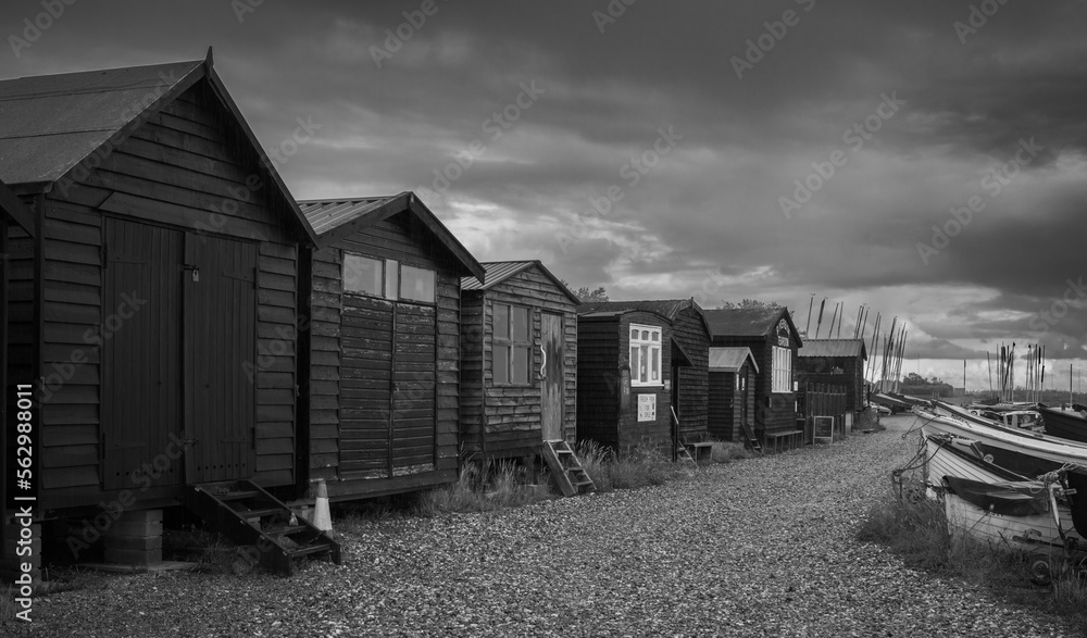 Naklejka premium Black and White image of fishing huts at Orford Quay, Orford, Suffolk on a stormy day