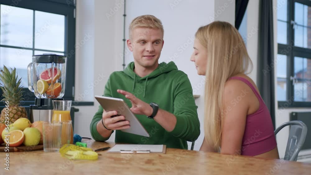 Young couple review fitness videos on computer tablet Young couple review fitness videos on computer tablet