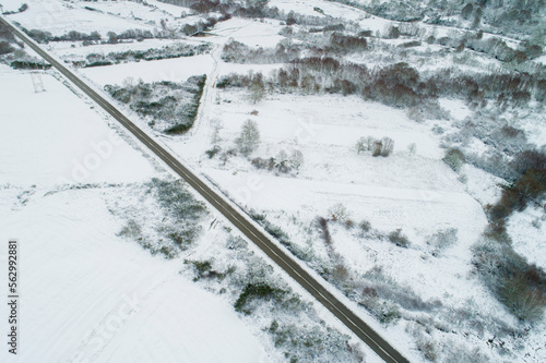 drone aerial view of a road in a snow-covered landscape, winter time concept