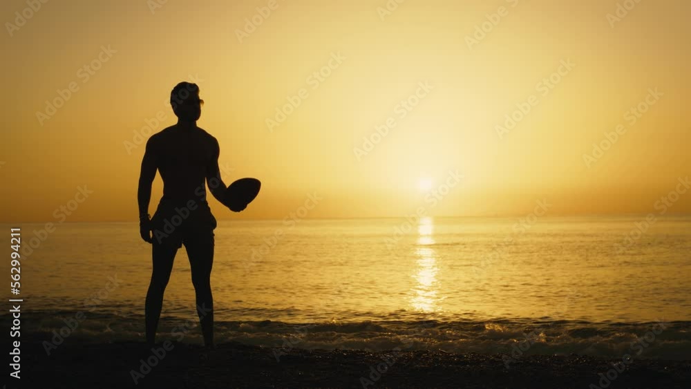 Silhouette of a man at sunset with American football ball Silhouette of a man at sunset with American football ball