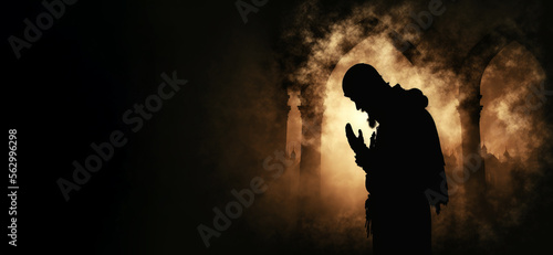 Fotografija Silhouette religious of muslim male praying in the mosque