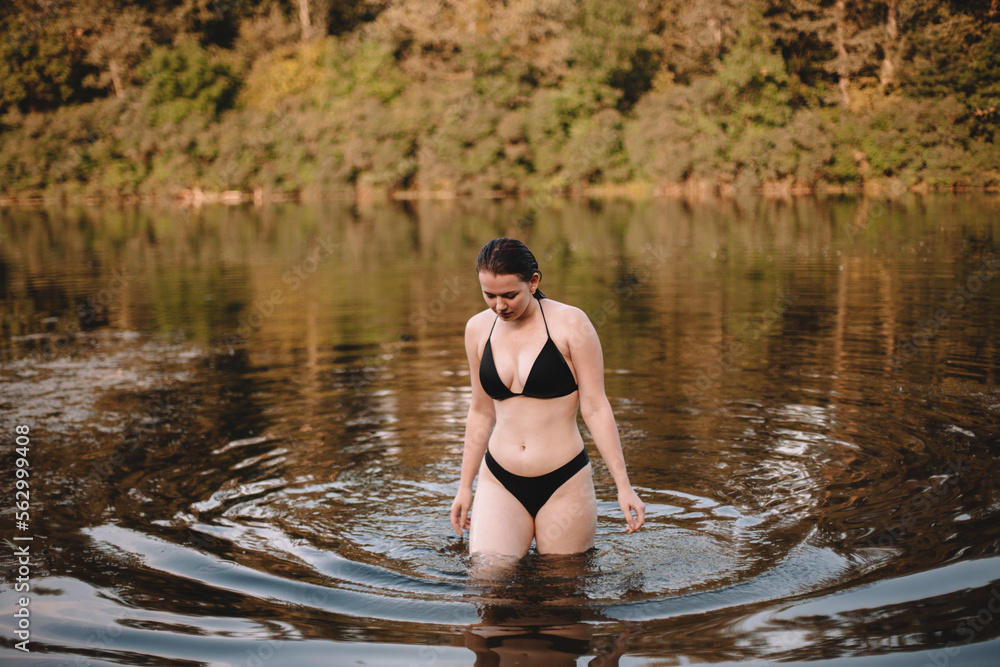 Young woman in a bikini walking in lake Young woman in a bikini walking in lake
