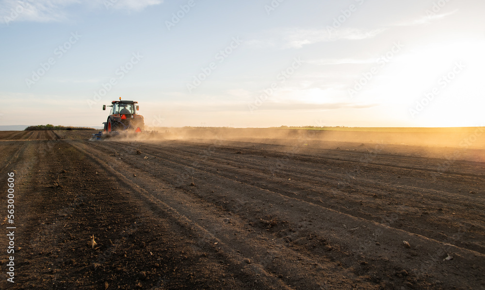 Fototapeta premium Farmer preparing his field in a tractor