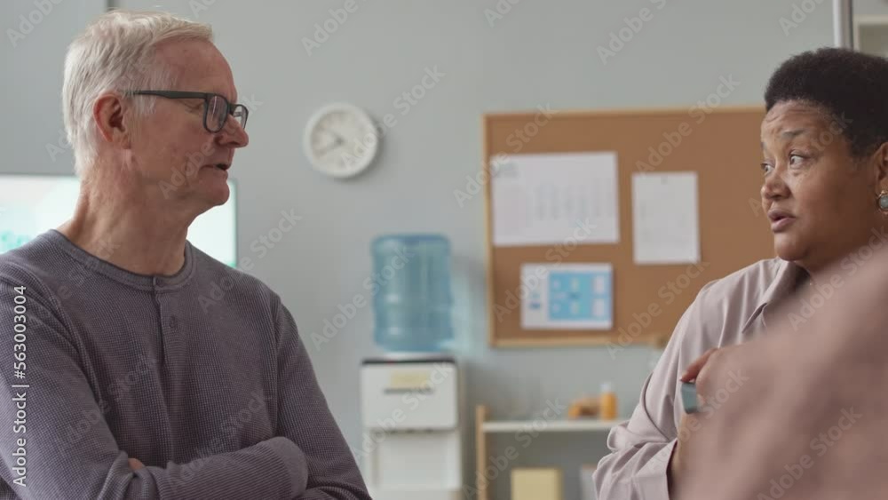 Multiethnic senior people having conversation sitting around table at nursing home Multiethnic senior people having conversation sitting around table at nursing home