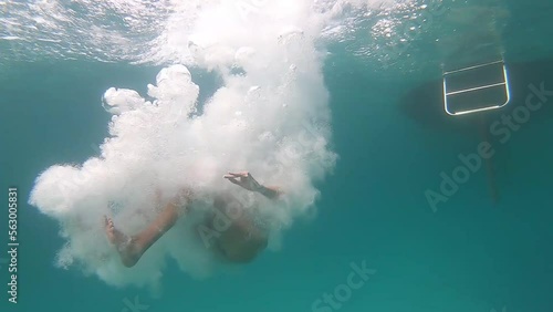 Girl jumps into the water from a yacht, slow motion underwater viewing photo