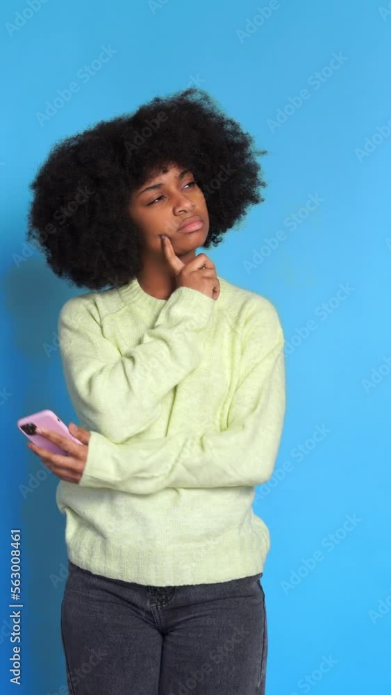 pensive Charming black woman with smartphone. Vertical video. pensive Charming black woman with smartphone. Vertical video.