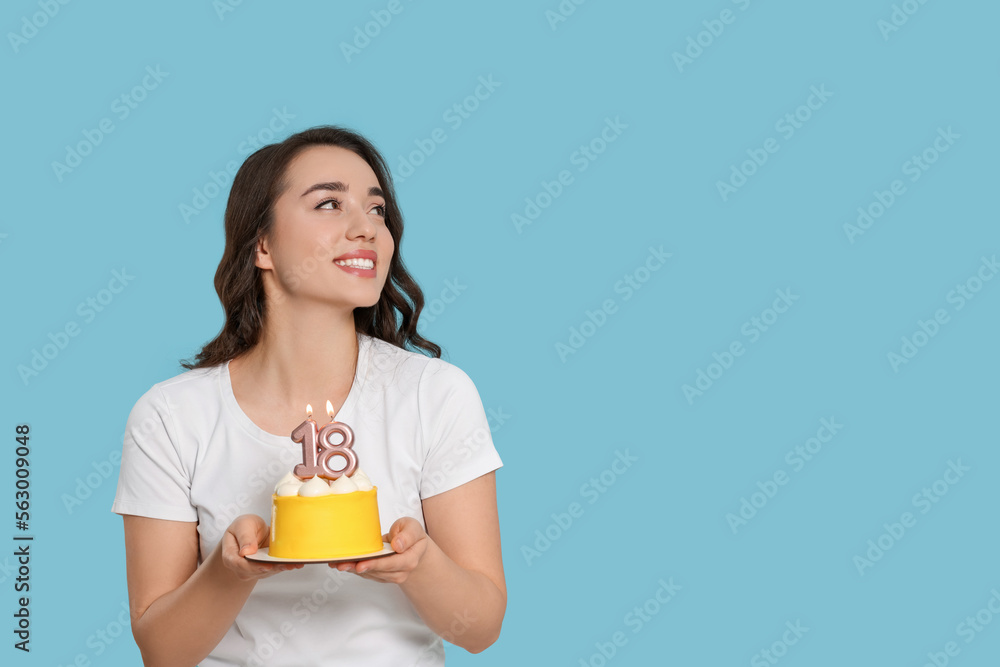 Coming of age party - 18th birthday. Woman holding delicious cake with number shaped candles on light blue background, space for text Coming of age party - 18th birthday. Woman holding delicious cake with number shaped candles on light blue background, space for text