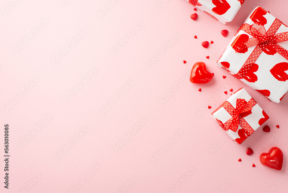 Valentine's Day concept. Top view photo of present boxes with ribbon bows heart shaped candles and sprinkles on isolated light pink background with empty space Valentine's Day concept. Top view photo of present boxes with ribbon bows heart shaped candles and sprinkles on isolated light pink background with empty space