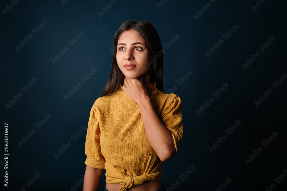 Brunette woman isolated over blue background holding her inflamed throat. Medical concept, Sore throat. Having sore throat, holding hand on her neck, suffering from throat pain, painful swallowing.