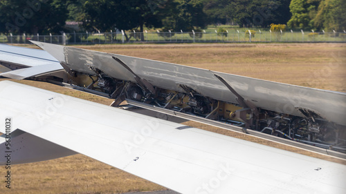 Wing braking of the aircraft on the runway. The wing of an aircraft open flaps on the wing for is landing.