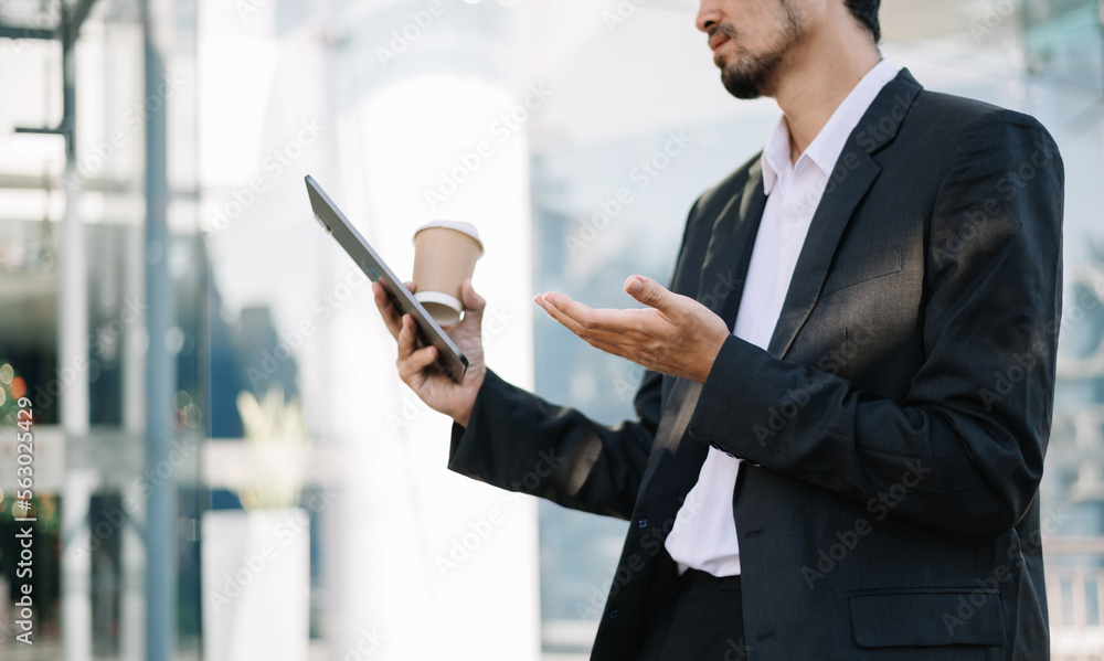 Young businessman using a tablet on a bench in the city.. Young businessman using a tablet on a bench in the city..