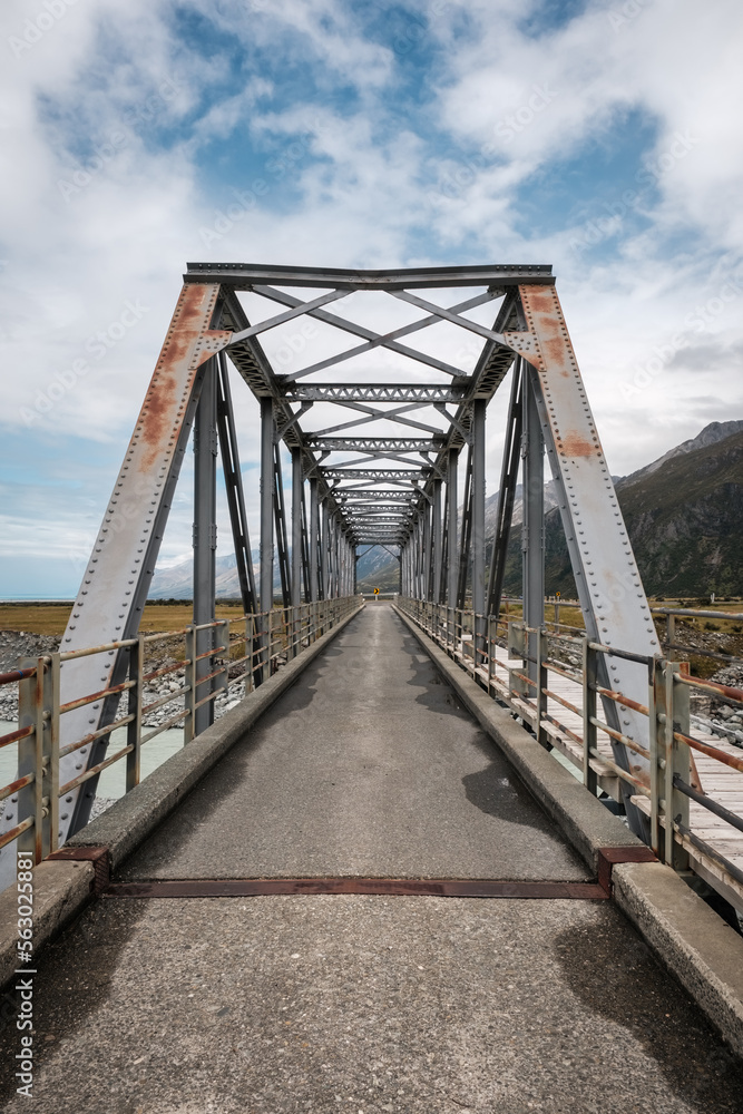 Iron bridge over the Hooker River near Mount Cook in the South Island of New Zealand with mountains in the distance