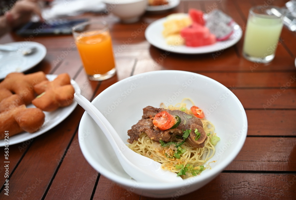 Noodles with braised pork without soup in white cup, plastic spoon. Yellow egg noodles with large chunks of stewed pork topped with sliced coriander and seasoned with sugar, vinegar and chilli.
Noodles with braised pork without soup in white cup, plastic spoon. Yellow egg noodles with large chunks of stewed pork topped with sliced coriander and seasoned with sugar, vinegar and chilli.