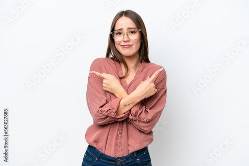 Young pretty caucasian woman isolated on white background pointing to the laterals having doubts © luismolinero