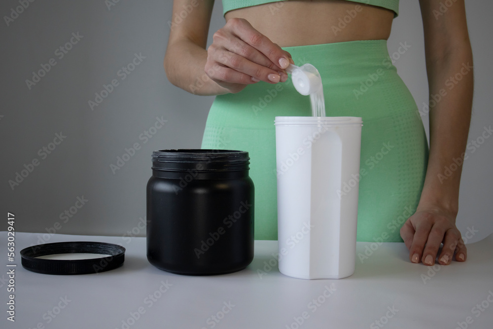 Close Up of Women with Measuring Scoop of Whey Protein, Jar and