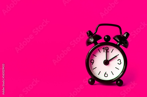 Alarm clock pointing at 2 am or pm with customizable space for text or ideas. Copy space with pink background