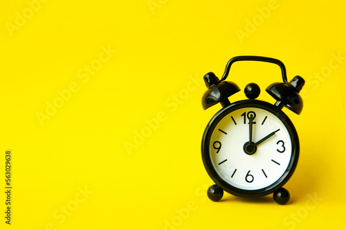 Alarm clock pointing at 2 am or pm with customizable space for text or ideas. Copy space with yellow background