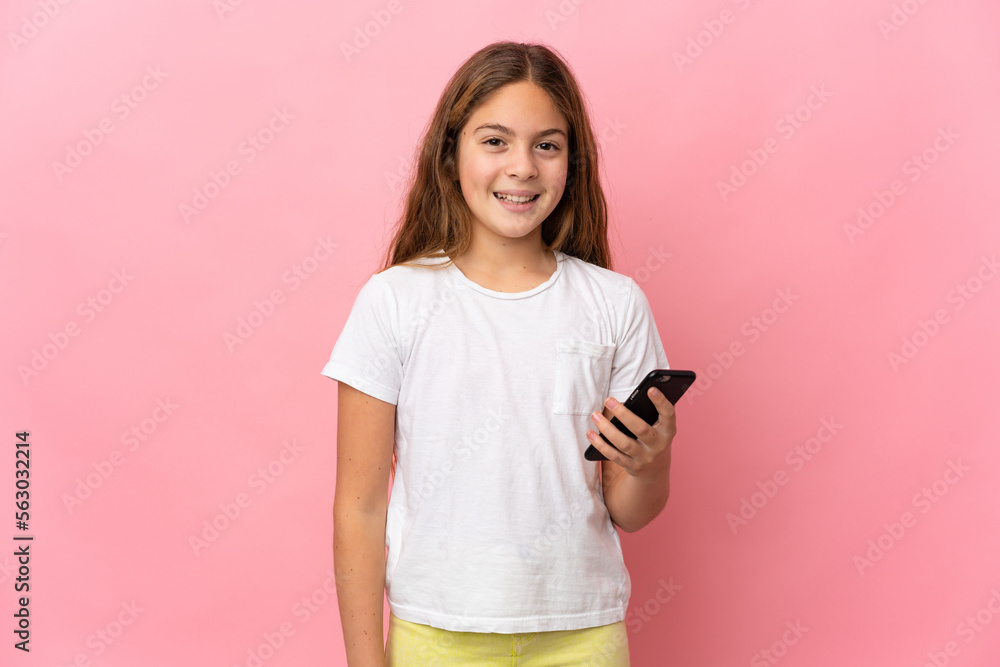 Child over isolated pink background using mobile phone Child over isolated pink background using mobile phone