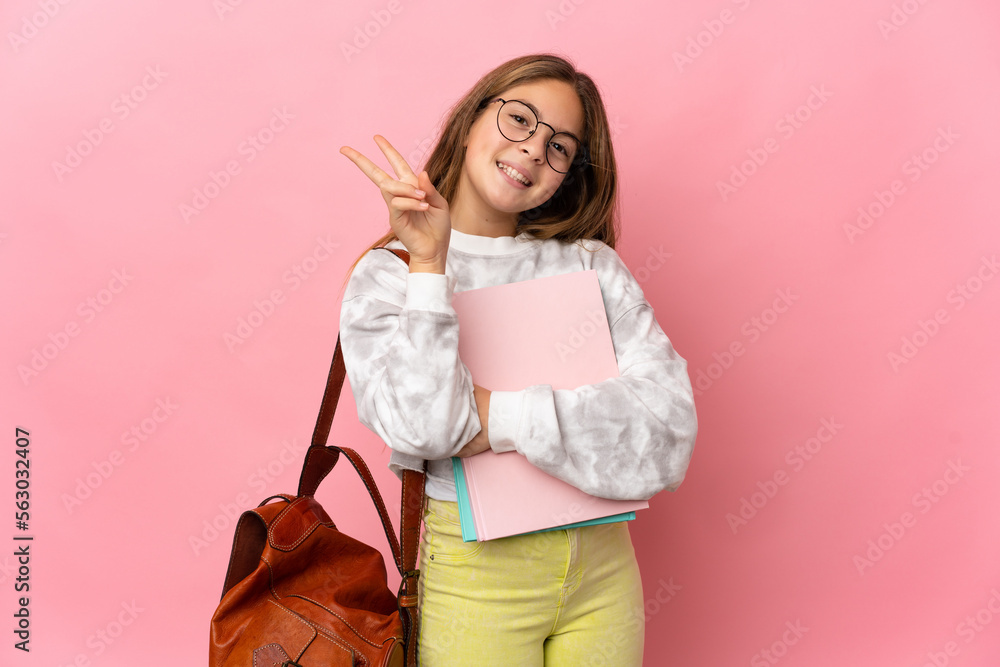 Student little girl over isolated pink background smiling and showing victory sign Student little girl over isolated pink background smiling and showing victory sign