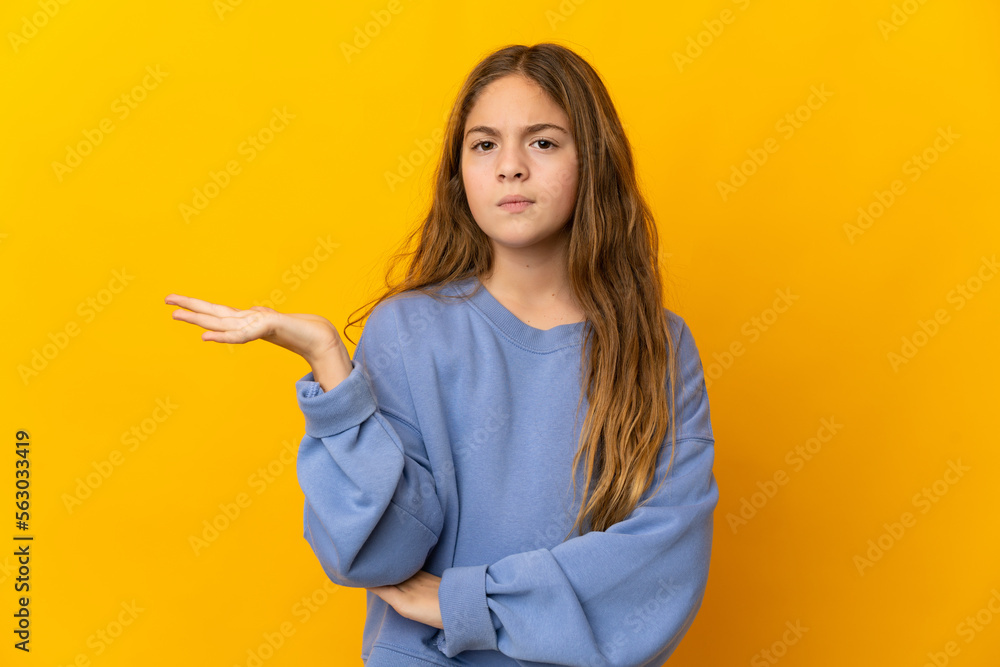 Child over isolated yellow background having doubts Child over isolated yellow background having doubts