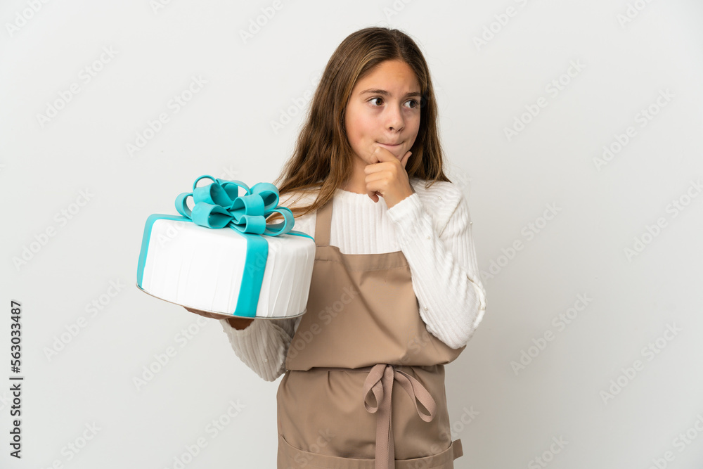 Little girl holding a big cake over isolated white background having doubts and thinking Little girl holding a big cake over isolated white background having doubts and thinking