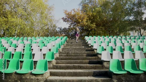 The girl leaves the football stadium . Canceled match, game. without fans. 