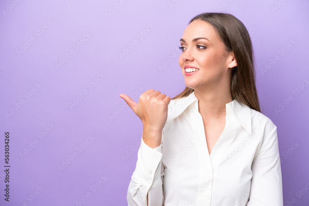 Young caucasian woman isolated on purple background pointing to the side to present a product Young caucasian woman isolated on purple background pointing to the side to present a product