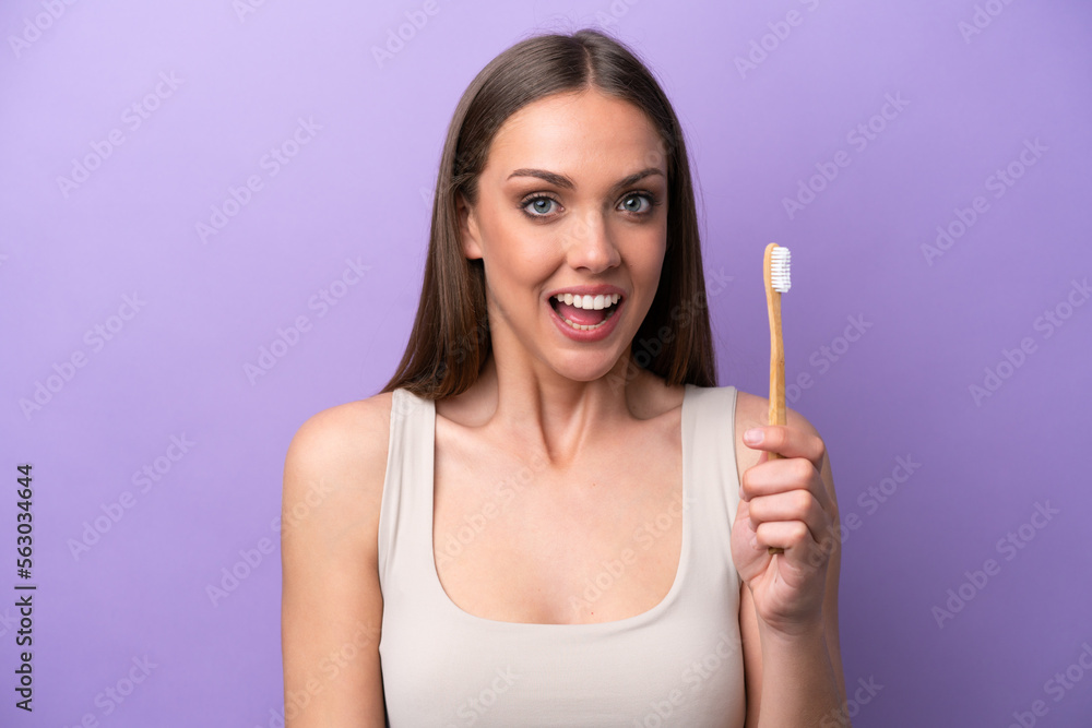 Young caucasian woman brushing teeth isolated on purple background with surprise and shocked facial expression Young caucasian woman brushing teeth isolated on purple background with surprise and shocked facial expression