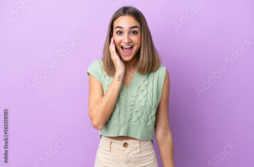 Young caucasian woman isolated on purple background with surprise and shocked facial expression © luismolinero