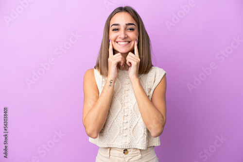 Young caucasian woman isolated on purple background smiling with a happy and pleasant expression