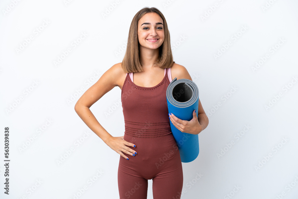 Young sport caucasian woman going to yoga classes isolated on white background posing with arms at hip and smiling Young sport caucasian woman going to yoga classes isolated on white background posing with arms at hip and smiling
