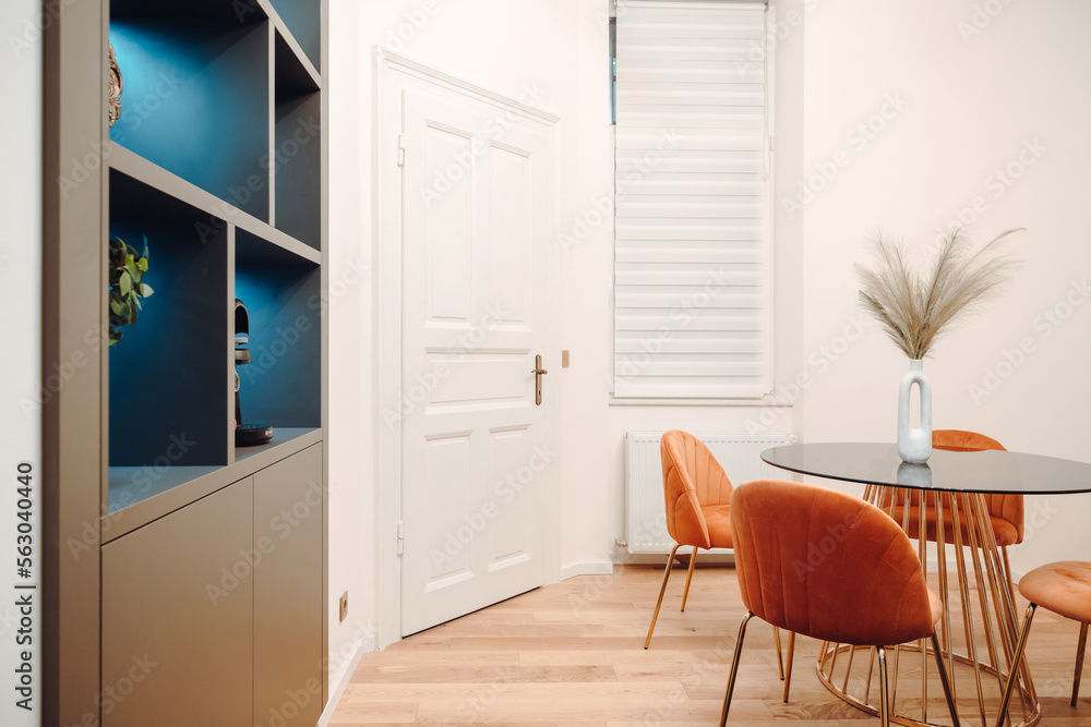 Fototapeta premium Orange chairs with round dining table in modern hi end kitchen