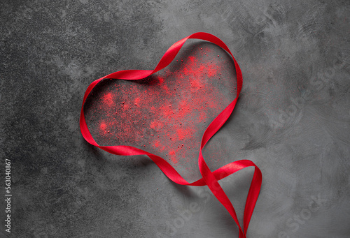 Heart shape from red ribbon on dark textured background. Valentine Day, love concept. top view