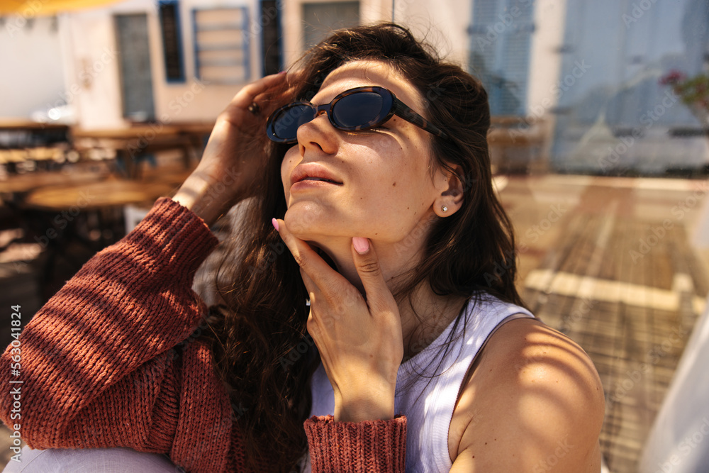 Close-up pretty young caucasian woman enjoying summer day with closed eyes outdoor. Brunette hair female wears white shirt and cardigan. Concept tenderness, sunshine. Close-up pretty young caucasian woman enjoying summer day with closed eyes outdoor. Brunette hair female wears white shirt and cardigan. Concept tenderness, sunshine.