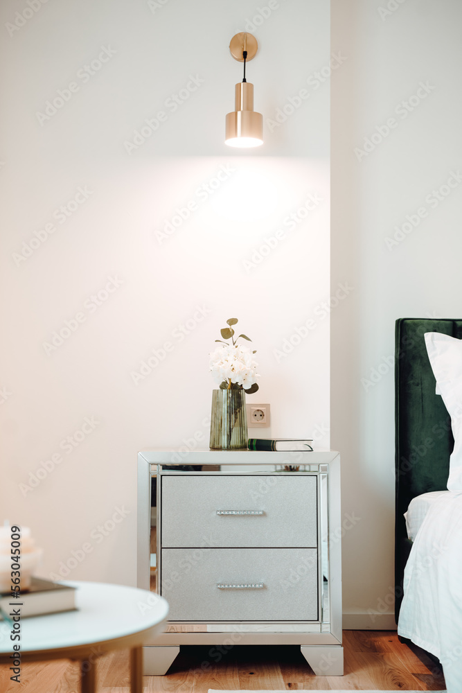 Fototapeta premium Close up of beautiful nightstand in elegant and comfortable modern bedroom. Interior design details