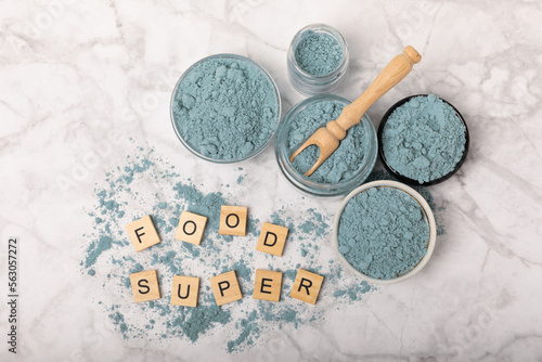 Blue Spirulina algae powder on white marble background. Diet and detox concept.Natural vegan superfood. Food supplement. Copy space. Place for text.