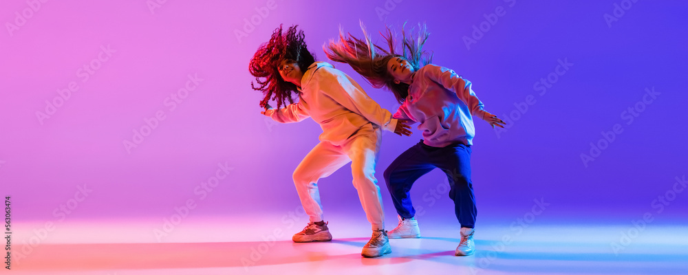 Music. Young expressive hip-hop dancers dancing in neon. Concept of dance, youth, hobby, dynamics, movement, action, ad. Banner - obrazy, fototapety, plakaty 