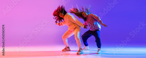 Music. Young expressive hip-hop dancers dancing in neon. Concept of dance, youth, hobby, dynamics, movement, action, ad. Banner