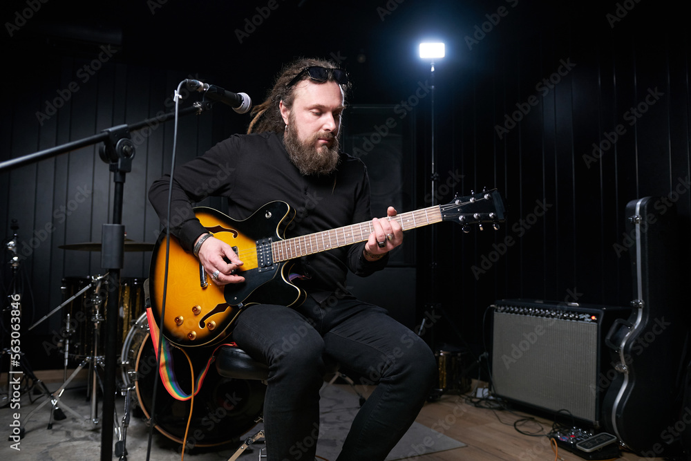 Fototapeta premium Guitarist man plays an electric guitar Close-up at studio