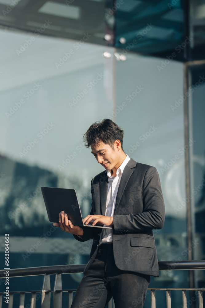 Handsome young manager working on laptop while sitting outdoors on the stairs, concept of work life balance. Handsome young manager working on laptop while sitting outdoors on the stairs, concept of work life balance.