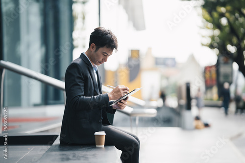 Portrait of asian businessman holding digital computer tablet. stock market concept.