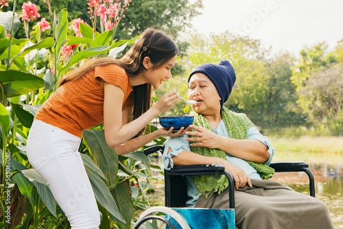Фотография Daughter taking care health elderly mother who is sick with cancer sitting in wh