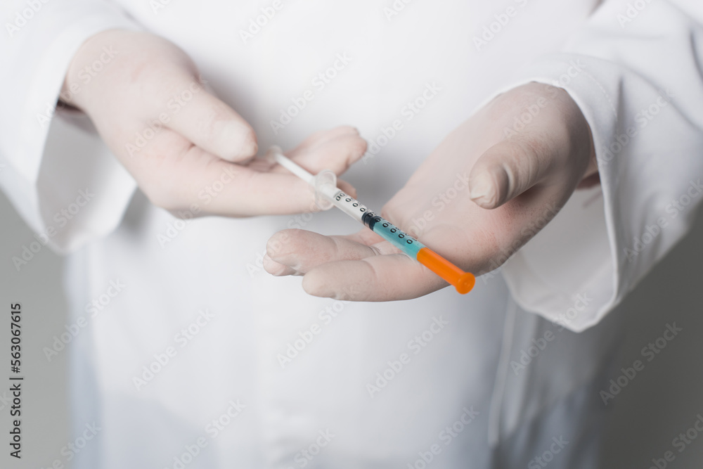 Cropped view of doctor in latex gloves holding syringe with vaccine on grey background. Cropped view of doctor in latex gloves holding syringe with vaccine on grey background.