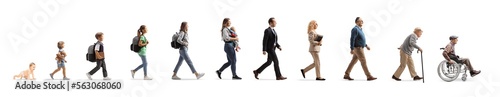 Full length profile shot of a group of people walking, from a baby crawling to a senior