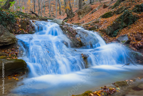 Fototapeta Naklejka Na Ścianę i Meble -  river with waterfall rushing through the mountain canyon among stones and dry leaves