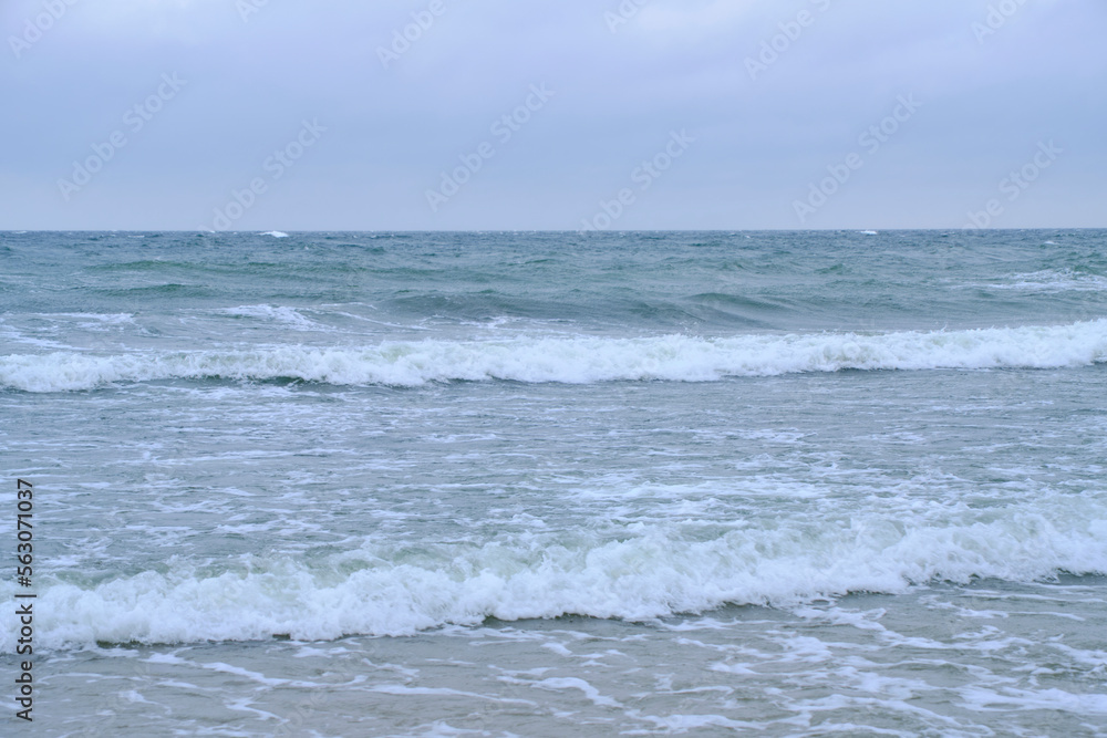 Rolling waves on sandy beach Baltic Sea.