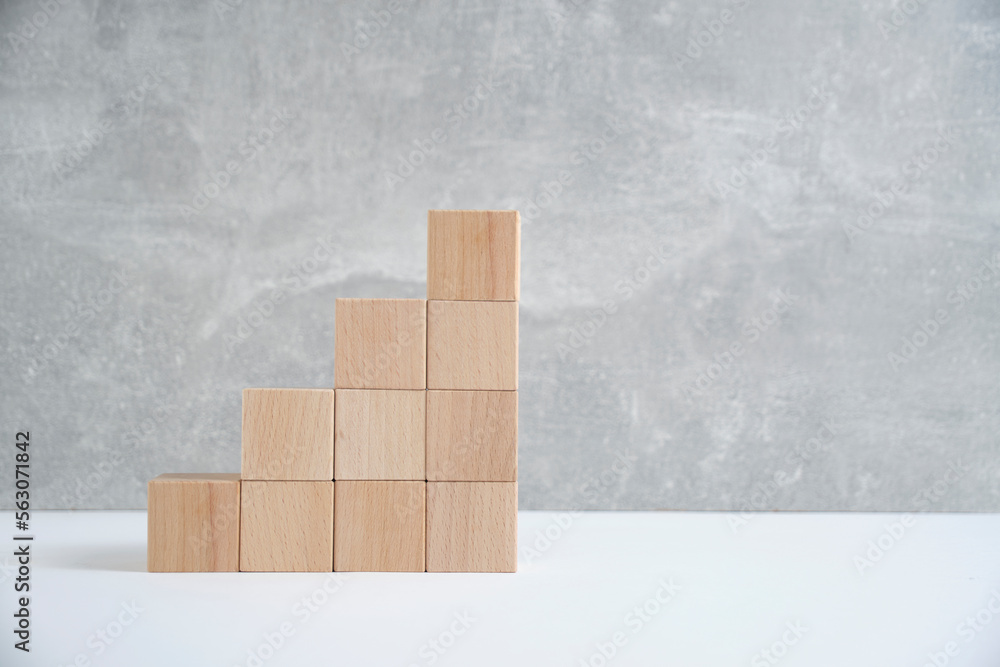 Steps made of wooden cubes light concrete background.Empty space for text. Steps made of wooden cubes light concrete background.Empty space for text.